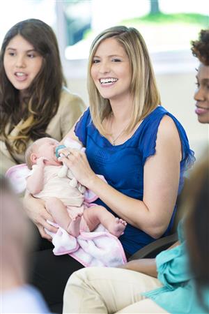 young women sitting in group with baby 